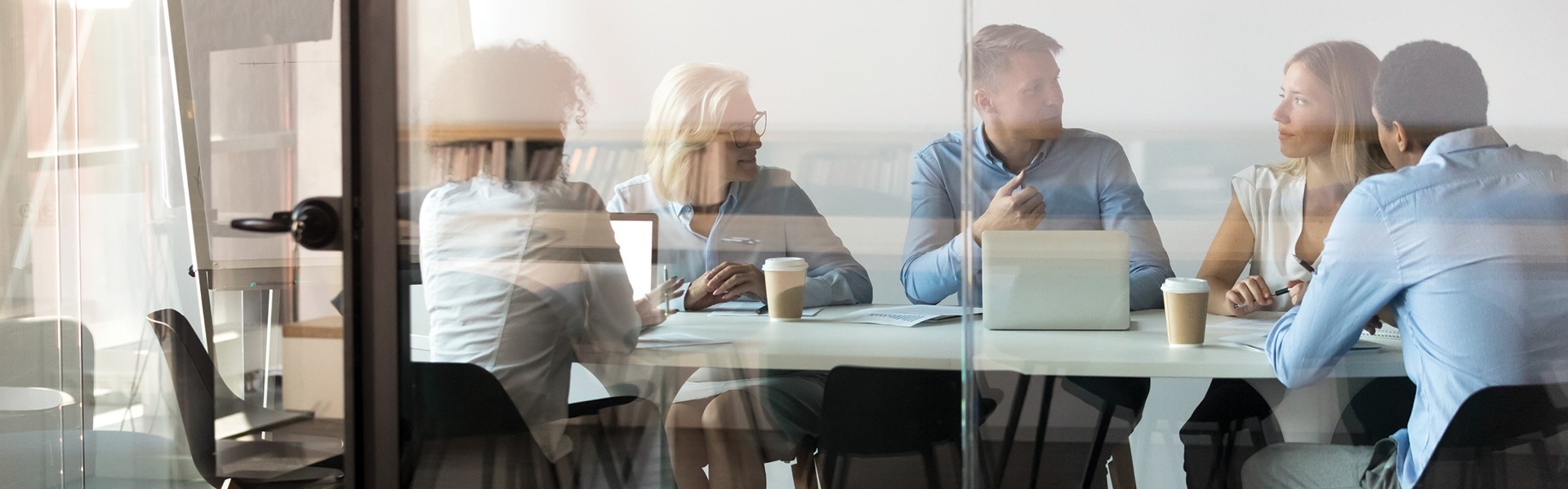 Work colleagues sitting around a meeting room table